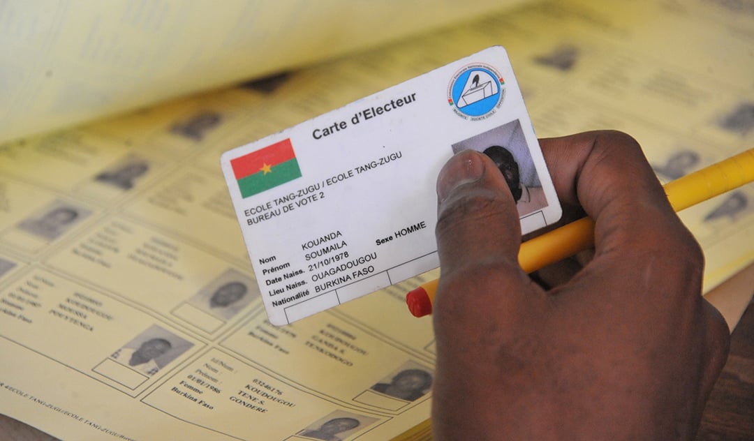 Un électeur présente sa carte, lors des élections municipales de 2016, à Ouagadougou.