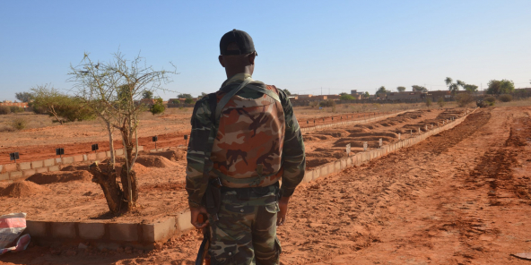 Un soldat nigérien devant les tombes des 71 militaires tués lors d’une attaque djihadiste le 10 décembre 2019.