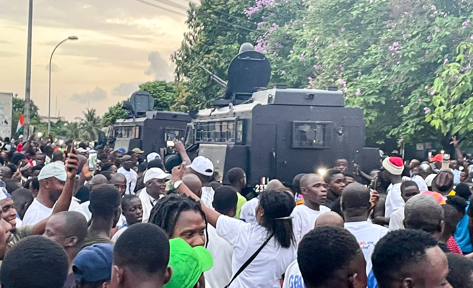 Des blindés des forces de l’ordre au milieu de la foule de partisans de Laurent Gbagbo, près du QG du FPI à Attoban, le 17 juin 2021, au moment de l’arrivée de l’ancien président ivoirien.